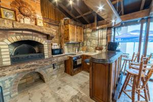 a kitchen with a stone fireplace and a stove at Smokinite Villa 1 - Pool and BBQ near the beach in Varna City