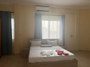 a bedroom with a bed with red shoes on it at Lilia Business Hotel in Ouagadougou
