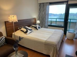 a bedroom with a bed and a large window at Hotelli Terme 425 in Kilvakkala