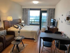 a bedroom with a bed and a living room at Hotelli Terme 425 in Kilvakkala