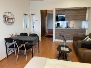 a living room with a table and a kitchen at Hotelli Terme 425 in Kilvakkala