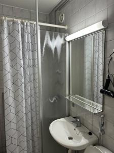 a bathroom with a sink and a shower curtain at Hotelli Terme 425 in Kilvakkala