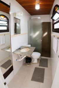 a bathroom with a toilet and a sink and a shower at Nova Perola de Guaruja in Guarujá +14 photos