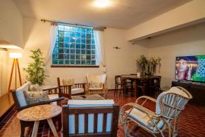 a living room filled with furniture and a tv at Posada los Cedros in La Cumbre