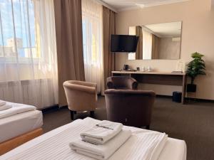 a hotel room with two beds and a desk and a mirror at Noclegi-Restauracja Boss in Mogilno