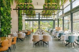 a restaurant with tables and chairs and plants at Palmera Resort Wellness & SPA in Kyrenia