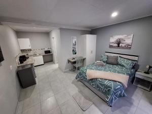 a large bedroom with a bed and a kitchen at Ivy Roots Guest House in Mokopane