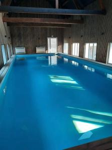 a large swimming pool with blue water in a room at Le domaine des amours in Saint-Josse +6 photos