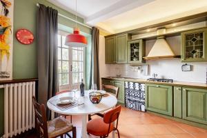 a kitchen with a table and some chairs and a table and a kitchen at Tuscan Sunrise Home in Monteriggioni +8 photos