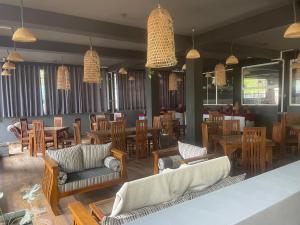 a restaurant with couches and tables and chairs at D & D Beach Resort in Trincomalee