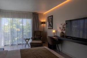 a hotel room with a bed and a flat screen tv at Tucan Resort & Spa in Paramaribo
