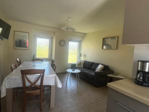 a kitchen and living room with a table and a couch at Gîtes du Clos du Ratz in Arradon