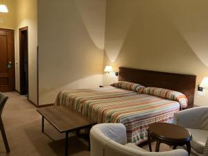 a hotel room with a bed and two chairs at Hotel Finca Los Venancios in Bones