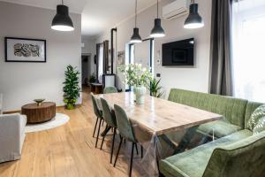 a living room with a wooden table and green chairs at Fioretti Home in San Giorgio Montagna