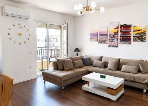a living room with a couch and a table at Romantic Penthouse with Mountains View in Kashari