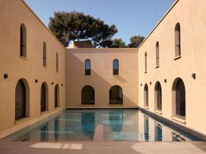 an empty courtyard with a pool in a building at Zannier Île de Bendor in Bandol