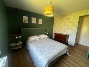 a bedroom with a bed and a green wall at Gîtes du Clos du Ratz in Arradon