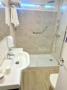 a white bathroom with a sink and a shower at Hotel Xaine Park in Lloret de Mar +42 photos