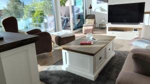 a living room with a couch and a tv and a table at Ferienwohnung Boddenblick-Vilm in Putbus