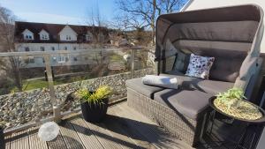 a balcony with a couch and a view of a house at Ferienwohnung Boddenblick-Vilm in Putbus