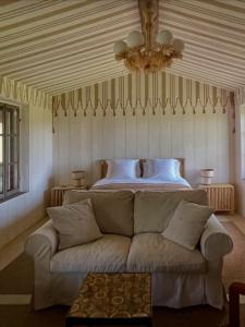 ein Schlafzimmer mit einem Bett und einer Couch vor dem Bett in der Unterkunft Villa Leopardi in Vignale