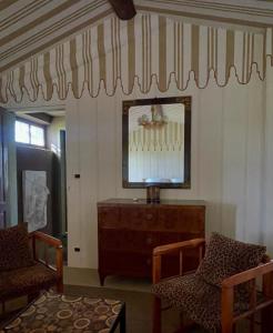 ein Wohnzimmer mit Fernseher und zwei Sesseln in der Unterkunft Villa Leopardi in Vignale