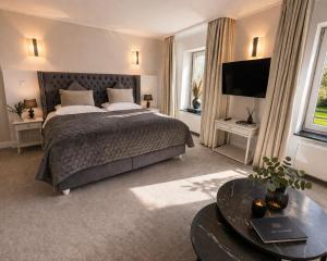 a bedroom with a large bed and a television at Gut Dyckhof in Meerbusch