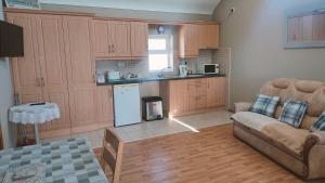 a living room with a couch and a kitchen at Danubio Guest Accommodation in Doonbeg