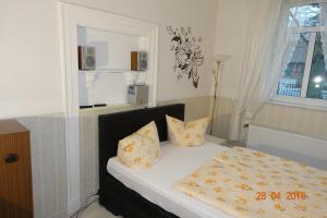 a bedroom with a bed with pillows and a window at Heidehof Auenland in Wietzendorf
