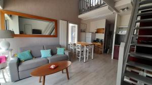 a living room with a couch and a table at T2 en duplex spacieux et central in Andernos-les-Bains +19 photos