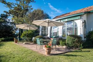 a patio with tables and chairs and umbrellas at Posada los Cedros in La Cumbre