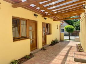 a patio with a wooden pergola on a house at Tündi Vendégház in Balatonlelle