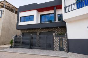 a modern house with black garage doors on it at Praia City Apartments in Praia