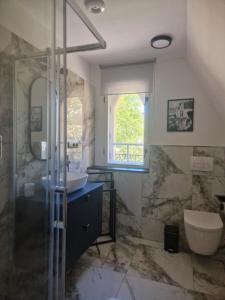 a bathroom with a sink and a glass shower at Apartmány Aurelius in Trenčín +73 photos