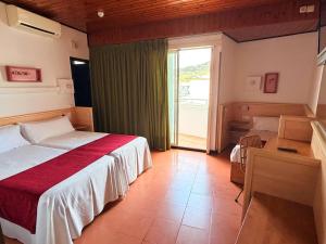 a bedroom with two beds and a large window at Hotel Xaine Park in Lloret de Mar