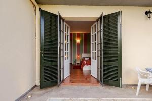 a hallway with green doors and a room with a bed at Tuscan Sunrise Home in Monteriggioni