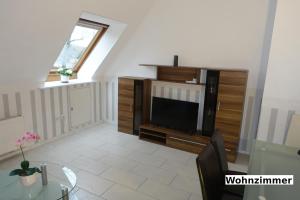 a living room with a tv and a table at Heidehof Auenland in Wietzendorf