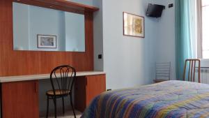 Hotel2000 في ميلانو: غرفة نوم بسرير ومرآة وكرسي