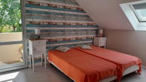 a bedroom with a bed and a wooden wall at T2 en duplex spacieux et central in Andernos-les-Bains