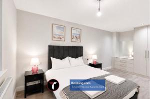a bedroom with a large white bed and two lamps at Spacious 4 Bedroom By Tara Stays Short Lets & Serviced Accommodation Aldershot With Free WiFi & Garden in Aldershot