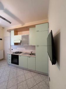 a kitchen with white cabinets and a refrigerator at Mare & Pineta in Punta Marina