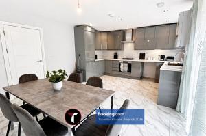 a kitchen and dining room with a table and chairs at Spacious 4 Bedroom By Tara Stays Short Lets & Serviced Accommodation Aldershot With Free WiFi & Garden in Aldershot