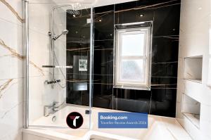 a shower in a bathroom with a sink and a window at Spacious 4 Bedroom By Tara Stays Short Lets & Serviced Accommodation Aldershot With Free WiFi & Garden in Aldershot +23 photos