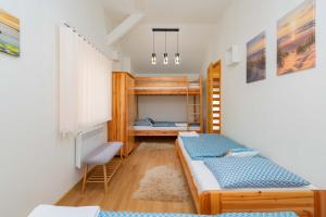 a bedroom with two beds and a desk at Bárka a Tiszához apartman in Tiszaug