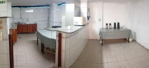 a kitchen with a counter and a table in it at Hotel Kairós in Campinas