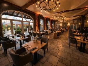 a restaurant with tables and chairs and a large window at Gut Dyckhof in Meerbusch