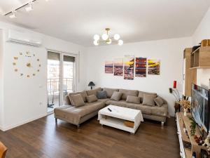 a living room with a couch and a table at Romantic Penthouse with Mountains View in Kashari
