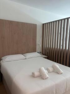 a bedroom with a large white bed with towels on it at Aravaca Palm in Madrid +14 photos