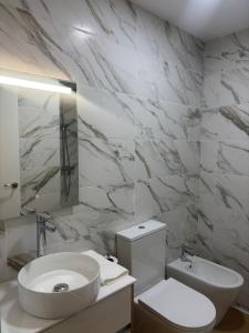 a white bathroom with a sink and a toilet at Aravaca Palm in Madrid