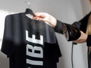a person is holding a black and white shirt at TRIBE Riga City Centre - Renovated 2026 in Riga